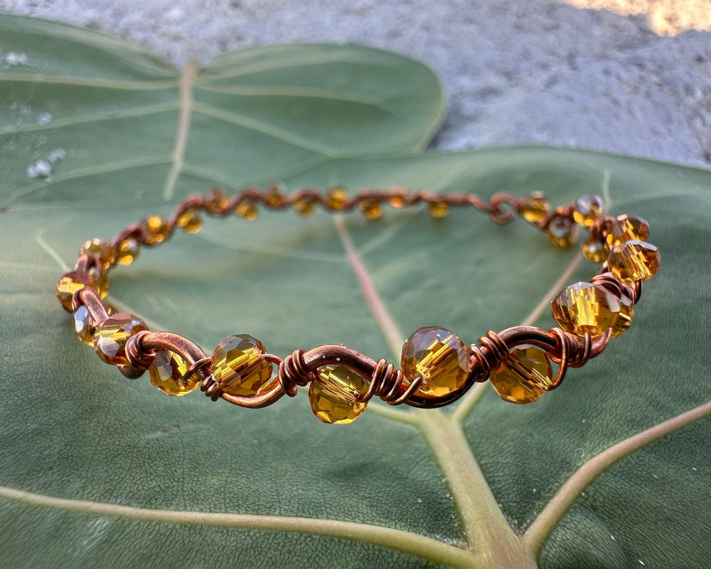 Bracelet with amber beads on a green leaf
